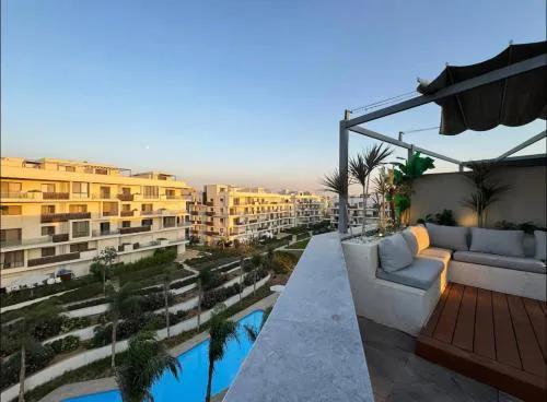 A luxurious bedroom and a cozy living area with a stunning view of the swimming pool